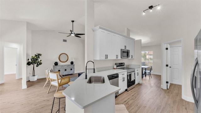 5458 Oakford Dr, Lakeland, FL 33812 - kitchen featuring appliances with stainless steel finishes, a sink, a kitchen breakfast bar, a ceiling fan, and light countertops