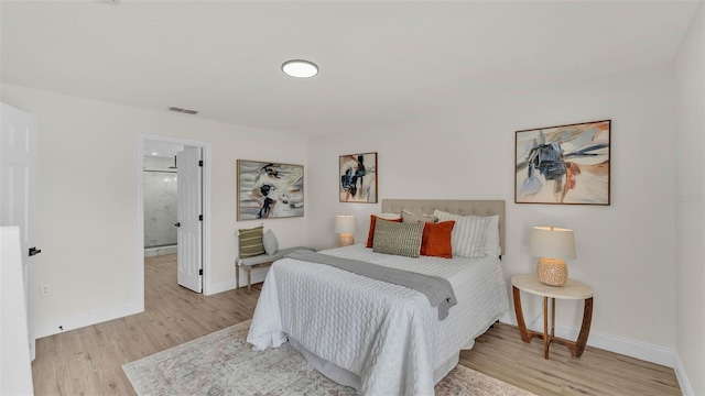 5458 Oakford Dr, Lakeland, FL 33812 - bedroom featuring light wood-style flooring, baseboards, and ensuite bathroom