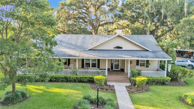 5108 Waterwood Dr, Bartow, FL 33830 - view of front facade with a shingled roof, covered porch, a chimney, and a front lawn