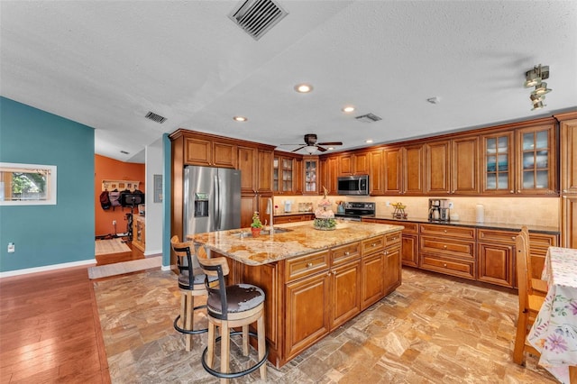5108 Waterwood Dr, Bartow, FL 33830 - kitchen featuring stainless steel appliances, brown cabinetry, recessed lighting, a textured ceiling, and a sink