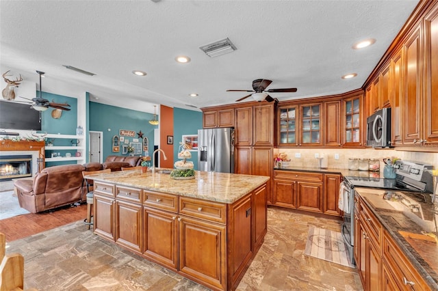 5108 Waterwood Dr, Bartow, FL 33830 - kitchen featuring appliances with stainless steel finishes, ceiling fan, brown cabinets, open floor plan, and recessed lighting