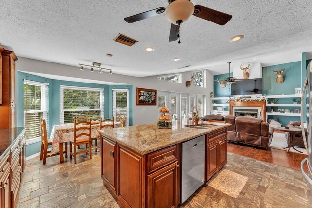 5108 Waterwood Dr, Bartow, FL 33830 - kitchen with stainless steel dishwasher, a sink, ceiling fan, a textured ceiling, and brown cabinetry