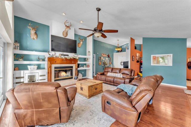 5108 Waterwood Dr, Bartow, FL 33830 - living area with lofted ceiling, a ceiling fan, wood finished floors, a high end fireplace, and baseboards