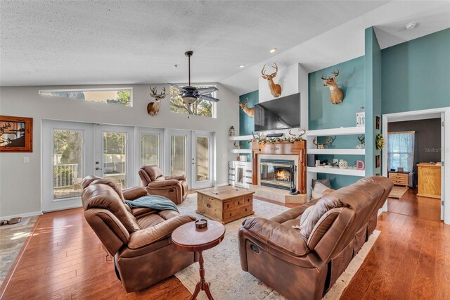 5108 Waterwood Dr, Bartow, FL 33830 - living room with ceiling fan, french doors, hardwood / wood-style floors, a glass covered fireplace, and high vaulted ceiling