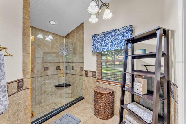 5108 Waterwood Dr, Bartow, FL 33830 - bathroom with tile walls, tile patterned flooring, a chandelier, a shower stall, and wainscoting