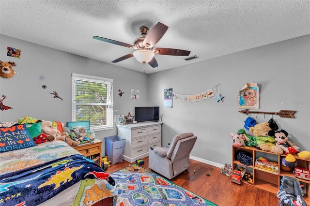 5108 Waterwood Dr, Bartow, FL 33830 - bedroom with a textured ceiling, wood finished floors, a ceiling fan, and baseboards