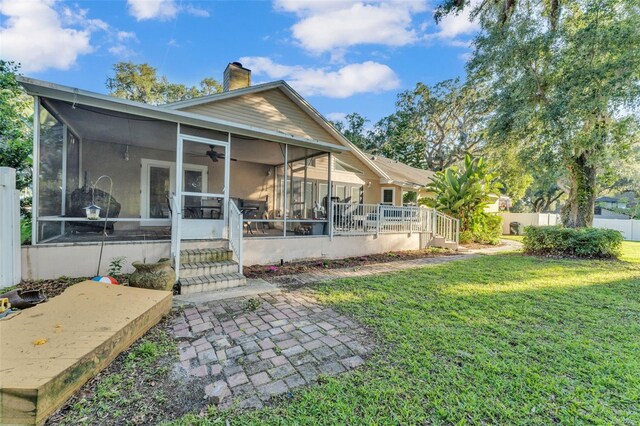 5108 Waterwood Dr, Bartow, FL 33830 - rear view of house with a sunroom, a ceiling fan, and a chimney