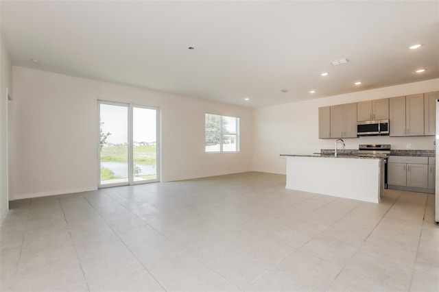606 Fairview Ave Unit 244, Haines City, FL 33844 - kitchen with appliances with stainless steel finishes, open floor plan, recessed lighting, gray cabinets, and an island with sink