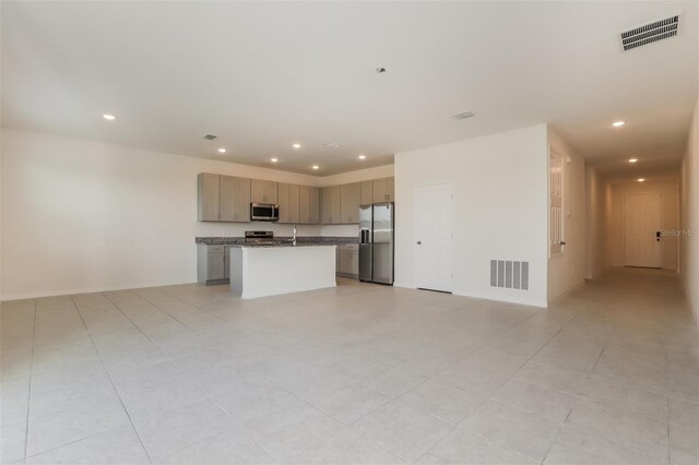606 Fairview Ave Unit 244, Haines City, FL 33844 - kitchen with appliances with stainless steel finishes, open floor plan, recessed lighting, a center island with sink, and gray cabinetry