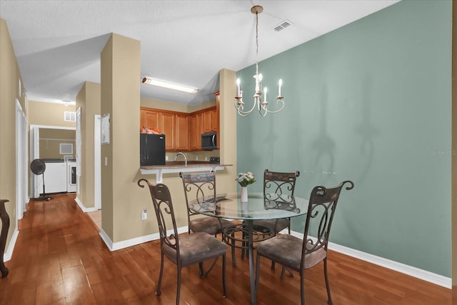 2061 Crestdale Ln Unit 60, Lake Mary, FL 32746 - dining area with a chandelier, wood finished floors, washer and dryer, and baseboards
