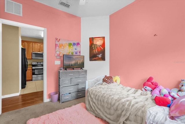 2061 Crestdale Ln Unit 60, Lake Mary, FL 32746 - bedroom with freestanding refrigerator, baseboards, light carpet, and ceiling fan