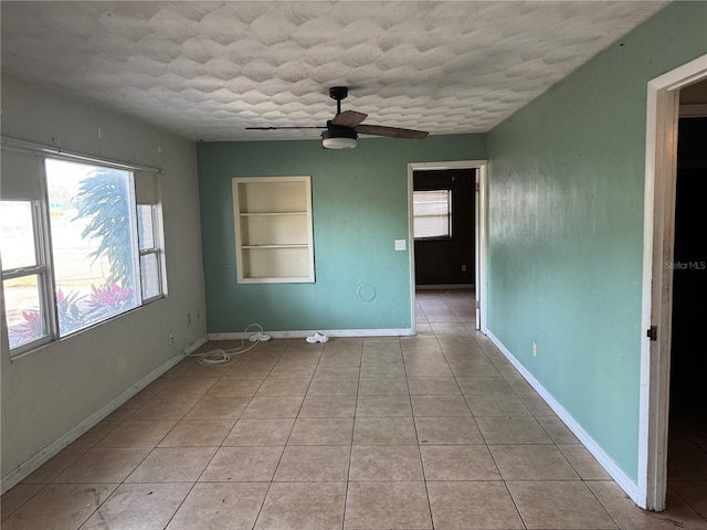 3651 Rifle Range Rd, Winter Haven, FL 33880 - unfurnished room featuring built in shelves, a ceiling fan, light tile patterned floors, a textured ceiling, and baseboards