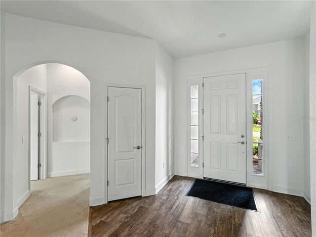 1547 Cordgrass Way, Lakeland, FL 33813 - entrance foyer featuring dark wood-type flooring, arched walkways, and baseboards
