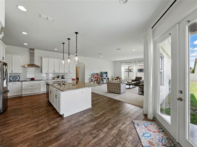 1547 Cordgrass Way, Lakeland, FL 33813 - kitchen with wall chimney range hood, a sink, healthy amount of natural light, open floor plan, and recessed lighting
