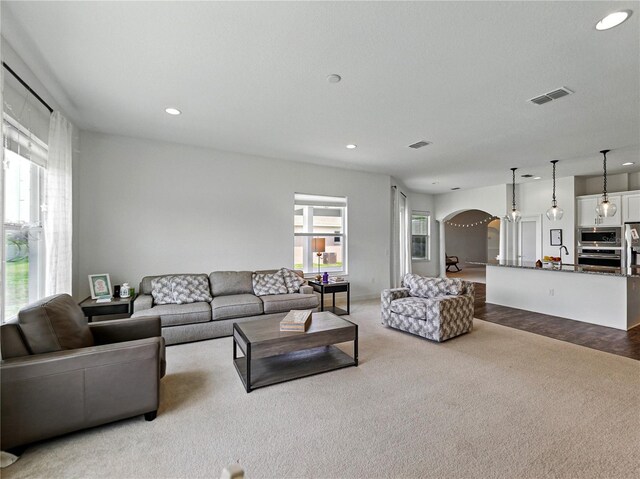 1547 Cordgrass Way, Lakeland, FL 33813 - carpeted living room with arched walkways, recessed lighting, and a sink