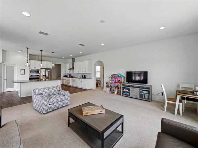 1547 Cordgrass Way, Lakeland, FL 33813 - living room featuring arched walkways, recessed lighting, and dark colored carpet