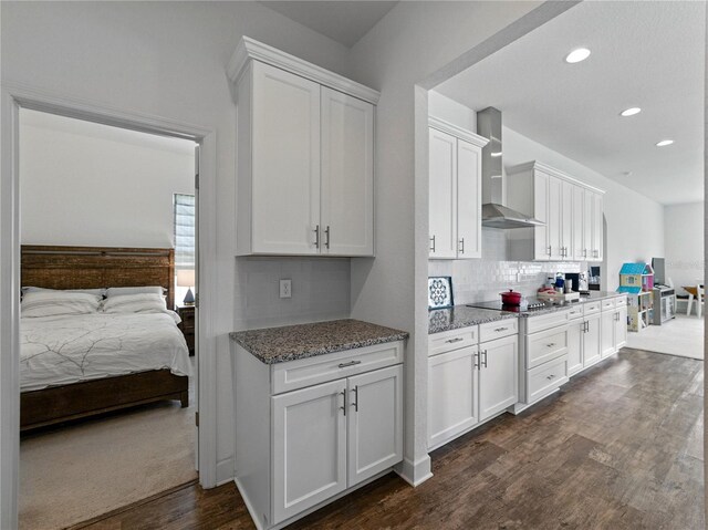 1547 Cordgrass Way, Lakeland, FL 33813 - kitchen featuring wall chimney exhaust hood, black electric stovetop, dark wood-style flooring, white cabinets, and recessed lighting