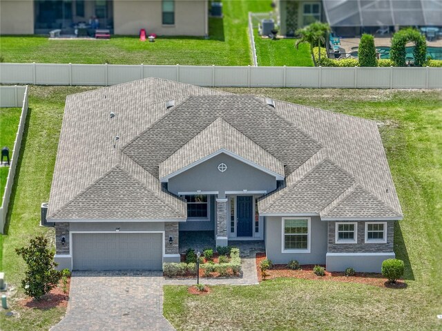 1547 Cordgrass Way, Lakeland, FL 33813 - view of front facade with roof with shingles, a garage, stucco siding, and decorative driveway