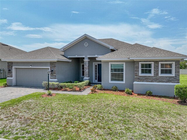 1547 Cordgrass Way, Lakeland, FL 33813 - view of front of home with roof with shingles, decorative driveway, a garage, and a front yard