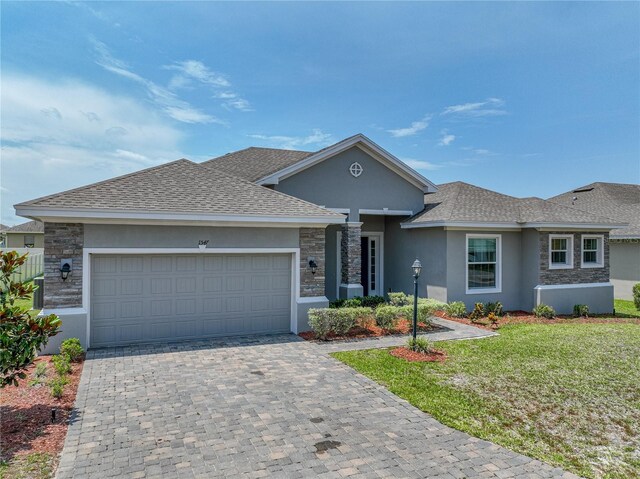 1547 Cordgrass Way, Lakeland, FL 33813 - view of front of property featuring stucco siding, stone siding, a front yard, and an attached garage