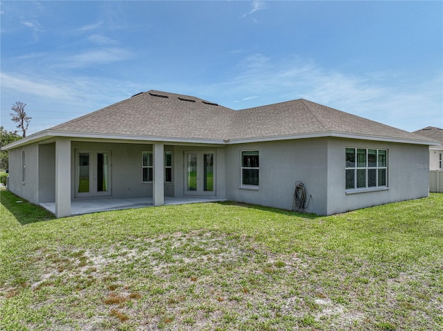 1547 Cordgrass Way, Lakeland, FL 33813 - rear view of house featuring stucco siding, french doors, a lawn, and roof with shingles