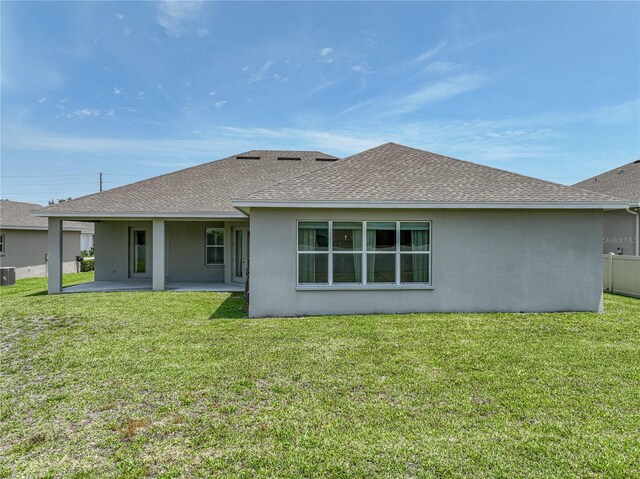 1547 Cordgrass Way, Lakeland, FL 33813 - rear view of property featuring stucco siding, roof with shingles, a patio area, and a lawn