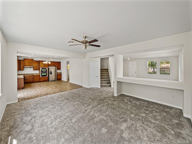 143 Alfani St, Davenport, FL 33896 - unfurnished living room with carpet flooring, baseboards, stairs, and a textured ceiling