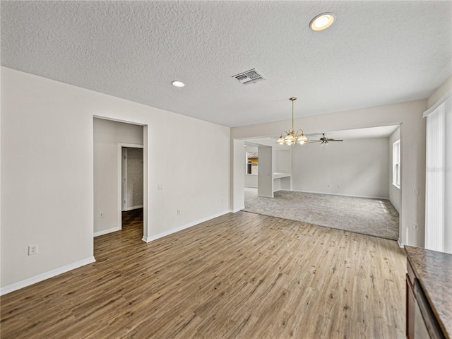 143 Alfani St, Davenport, FL 33896 - unfurnished living room with wood finished floors, a chandelier, a textured ceiling, baseboards, and recessed lighting