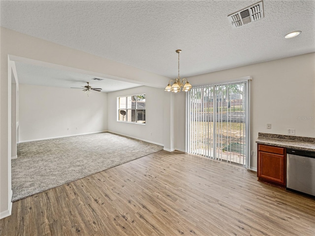 143 Alfani St, Davenport, FL 33896 - unfurnished dining area with light wood finished floors, a chandelier, ceiling fan, baseboards, and a textured ceiling