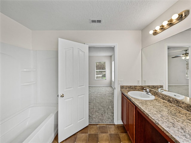 143 Alfani St, Davenport, FL 33896 - full bath with vanity, ceiling fan, shower / bathtub combination, a textured ceiling, and baseboards