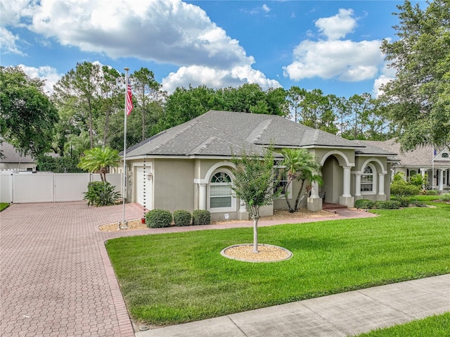 148 Melissa Trl, Auburndale, FL 33823 - view of front of home featuring stucco siding, decorative driveway, a shingled roof, and a garage