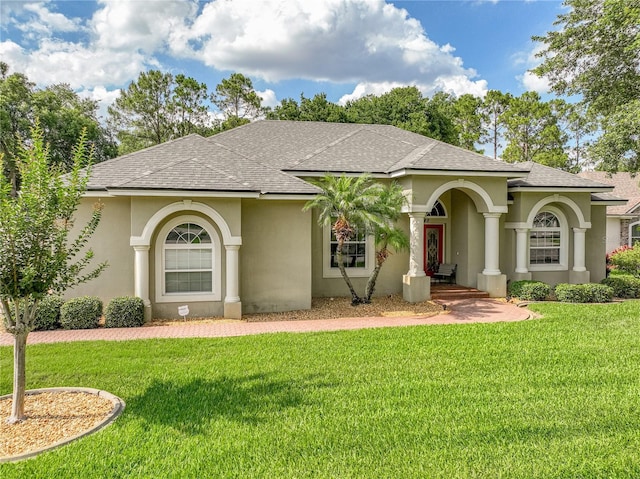 148 Melissa Trl, Auburndale, FL 33823 - mediterranean / spanish-style house featuring a shingled roof, stucco siding, and a front yard