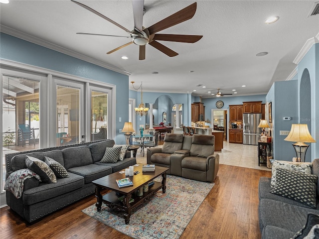 148 Melissa Trl, Auburndale, FL 33823 - living room featuring ceiling fan, ornamental molding, arched walkways, a chandelier, and light wood finished floors