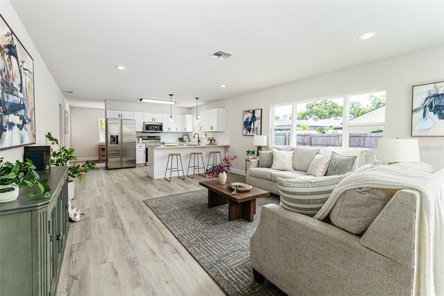 6338 Oak Sq E, Lakeland, FL 33813 - living room with light wood-type flooring, recessed lighting, and baseboards