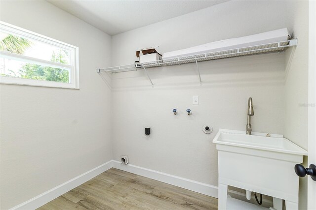 6338 Oak Sq E, Lakeland, FL 33813 - laundry room with light wood-style flooring, washer hookup, baseboards, and electric dryer hookup