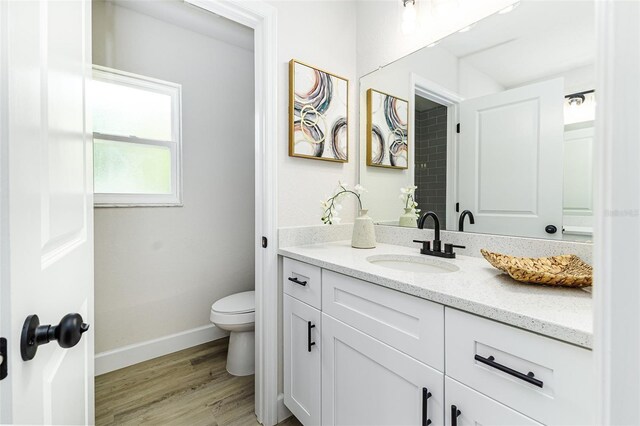 6338 Oak Sq E, Lakeland, FL 33813 - bathroom with vanity, toilet, wood finished floors, and baseboards