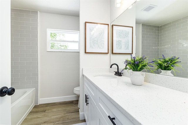 6338 Oak Sq E, Lakeland, FL 33813 - bathroom featuring vanity, wood finished floors, toilet, baseboards, and shower / bath combination