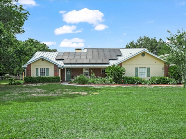 2921 W Socrum Loop Rd, Lakeland, FL 33810 - single story home featuring a front yard, roof mounted solar panels, brick siding, and metal roof