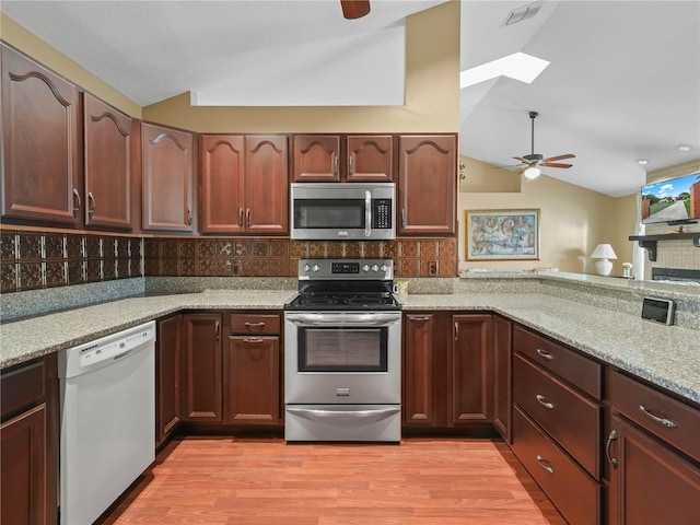2921 W Socrum Loop Rd, Lakeland, FL 33810 - kitchen featuring stainless steel appliances, vaulted ceiling, a ceiling fan, decorative backsplash, and a skylight