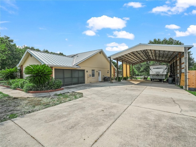 2921 W Socrum Loop Rd, Lakeland, FL 33810 - view of front of house with concrete driveway, stucco siding, a standing seam roof, and metal roof