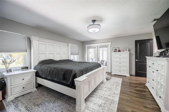 7608 Franklin Rd, Plant City, FL 33565 - bedroom featuring access to exterior, wood finished floors, french doors, and a textured ceiling