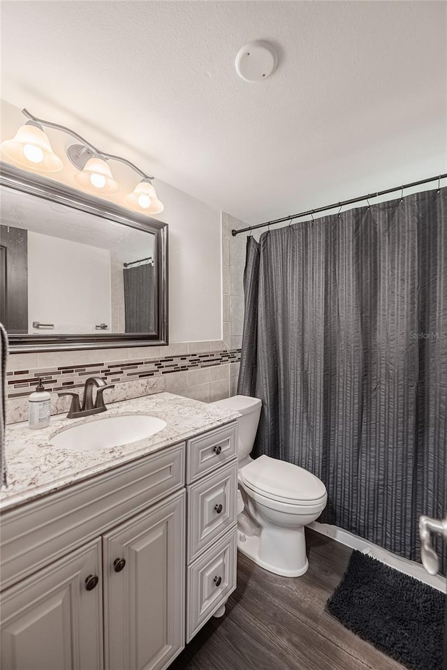 7608 Franklin Rd, Plant City, FL 33565 - bathroom featuring toilet, vanity, wood finished floors, and tile walls