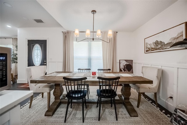7608 Franklin Rd, Plant City, FL 33565 - dining area with a decorative wall, a wainscoted wall, wood finished floors, and a chandelier