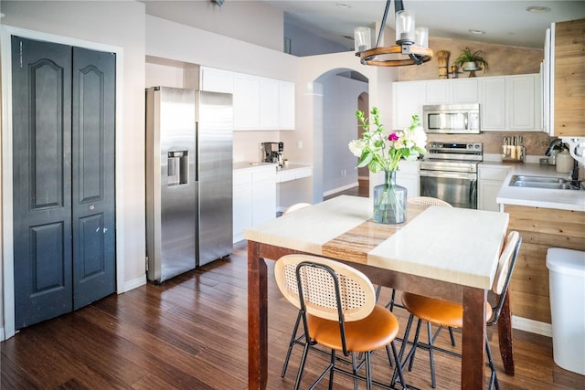 11567 Misty Isle Ln, Riverview, FL 33579 - kitchen with appliances with stainless steel finishes, arched walkways, a sink, dark wood finished floors, and vaulted ceiling