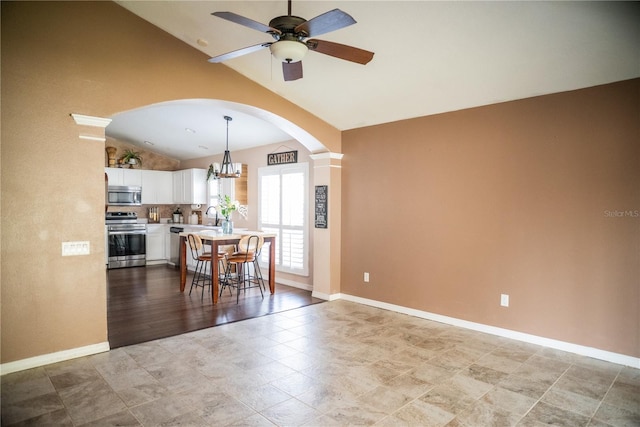 11567 Misty Isle Ln, Riverview, FL 33579 - kitchen with appliances with stainless steel finishes, lofted ceiling, arched walkways, light countertops, and a ceiling fan