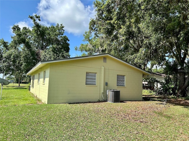 304 Bell St, Wauchula, FL 33873 - view of home's exterior featuring central AC unit, a yard, and concrete block siding