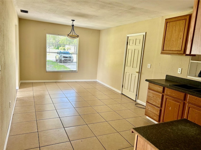 304 Bell St, Wauchula, FL 33873 - unfurnished dining area featuring a sink, light tile patterned flooring, a textured ceiling, and baseboards