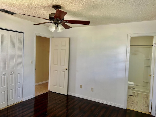 304 Bell St, Wauchula, FL 33873 - unfurnished bedroom with a closet, wood finished floors, a textured ceiling, baseboards, and connected bathroom