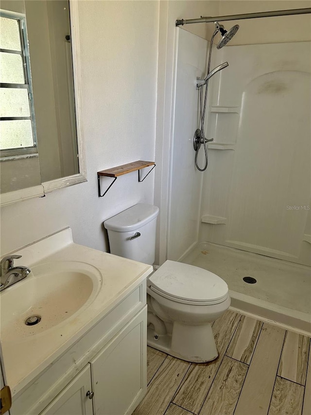 304 Bell St, Wauchula, FL 33873 - bathroom with walk in shower, wood finished floors, vanity, and toilet