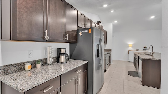 2966 Flying Blackbird Rd, Bartow, FL 33830 - kitchen with a sink, dark brown cabinetry, stainless steel appliances, light stone counters, and light tile patterned flooring